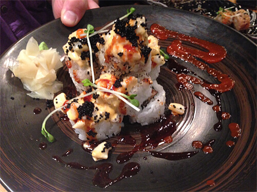 Volcano rolls - hot spicy chopped scallops, squid and tobiko sauce over an avocado and eel roll - $16.95